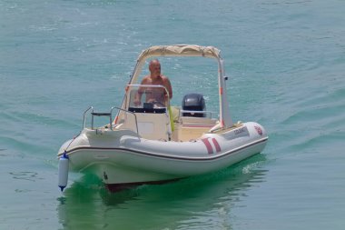 İtalya, Sicilya, Akdeniz, Marina di Ragusa (Ragusa Eyaleti); 1 Ağustos 2021, limandaki kauçuk bir teknede adam - EDITORIAL