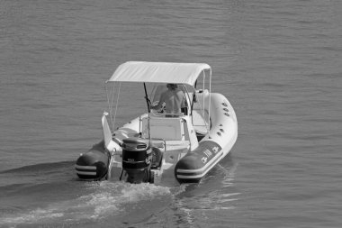 İtalya, Sicilya, Akdeniz, Marina di Ragusa (Ragusa Eyaleti); 1 Ağustos 2021, limandaki kauçuk bir teknede adam - EDITORIAL