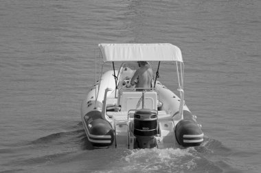 İtalya, Sicilya, Akdeniz, Marina di Ragusa (Ragusa Eyaleti); 1 Ağustos 2021, limandaki kauçuk bir teknede adam - EDITORIAL