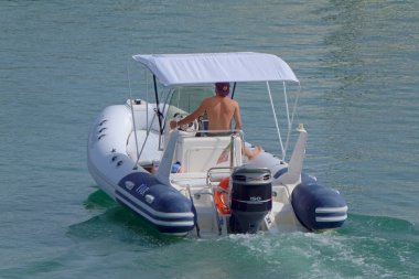 İtalya, Sicilya, Akdeniz, Marina di Ragusa (Ragusa Eyaleti); 1 Ağustos 2021, limandaki kauçuk bir teknede adam - EDITORIAL