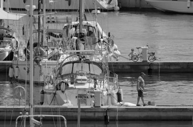 İtalya, Sicilya, Akdeniz, Marina di Ragusa (Ragusa ili); 2 Ağustos 2021, limandaki insanlar ve lüks yatlar - EDITORIAL