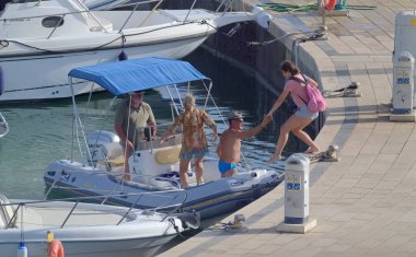 İtalya, Sicilya, Akdeniz, Marina di Ragusa (Ragusa ili); 2 Ağustos 2021, limandaki kauçuk bir teknede insanlar - EDITORIAL