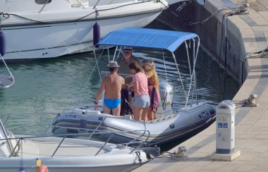 İtalya, Sicilya, Akdeniz, Marina di Ragusa (Ragusa ili); 2 Ağustos 2021, limandaki kauçuk bir teknede insanlar - EDITORIAL