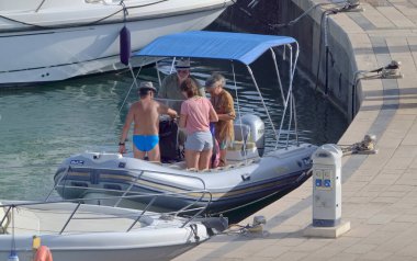 İtalya, Sicilya, Akdeniz, Marina di Ragusa (Ragusa ili); 2 Ağustos 2021, limandaki kauçuk bir teknede insanlar - EDITORIAL