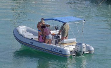 İtalya, Sicilya, Akdeniz, Marina di Ragusa (Ragusa ili); 2 Ağustos 2021, limandaki kauçuk bir teknede insanlar - EDITORIAL