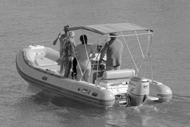 İtalya, Sicilya, Akdeniz, Marina di Ragusa (Ragusa ili); 2 Ağustos 2021, limandaki kauçuk bir teknede insanlar - EDITORIAL