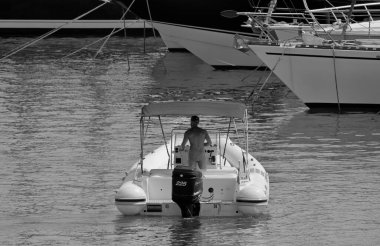 İtalya, Sicilya, Akdeniz, Marina di Ragusa (Ragusa Eyaleti); 4 Ağustos 2021, limanda kauçuk bir tekne ve lüks yatlarda adam - EDITORIAL