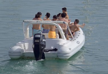 İtalya, Sicilya, Akdeniz, Marina di Ragusa (Ragusa Eyaleti); 4 Ağustos 2021, limandaki kauçuk bir teknede insanlar - EDITORIAL