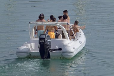 İtalya, Sicilya, Akdeniz, Marina di Ragusa (Ragusa Eyaleti); 4 Ağustos 2021, limandaki kauçuk bir teknede insanlar - EDITORIAL