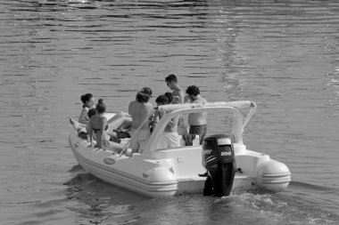 İtalya, Sicilya, Akdeniz, Marina di Ragusa (Ragusa Eyaleti); 4 Ağustos 2021, limandaki kauçuk bir teknede insanlar - EDITORIAL