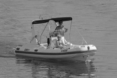 İtalya, Sicilya, Akdeniz, Marina di Ragusa (Ragusa Eyaleti); 4 Ağustos 2021, limandaki kauçuk bir teknede insanlar - EDITORIAL