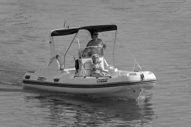 İtalya, Sicilya, Akdeniz, Marina di Ragusa (Ragusa Eyaleti); 4 Ağustos 2021, limandaki kauçuk bir teknede insanlar - EDITORIAL