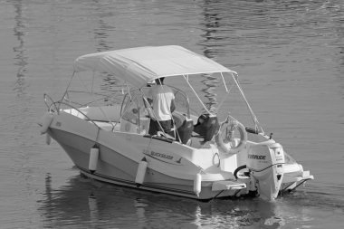 İtalya, Sicilya, Akdeniz, Marina di Ragusa (Ragusa Eyaleti); 4 Ağustos 2021, limandaki bir motorlu teknede adam - EDITORIAL