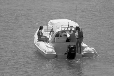 İtalya, Sicilya, Akdeniz, Marina di Ragusa (Ragusa ili); 7 Ağustos 2021, limandaki kauçuk bir teknede insanlar - EDITORIAL