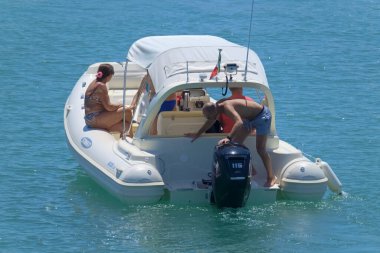 İtalya, Sicilya, Akdeniz, Marina di Ragusa (Ragusa ili); 7 Ağustos 2021, limandaki kauçuk bir teknede insanlar - EDITORIAL