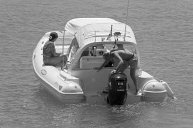 İtalya, Sicilya, Akdeniz, Marina di Ragusa (Ragusa ili); 7 Ağustos 2021, limandaki kauçuk bir teknede insanlar - EDITORIAL