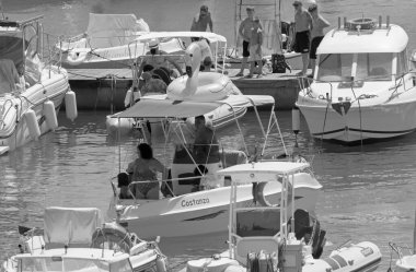 İtalya, Sicilya, Akdeniz, Marina di Ragusa (Ragusa ili); 7 Ağustos 2021, limandaki motorlu tekneler ve lüks yatlarda yaşayan insanlar - EDITORIAL