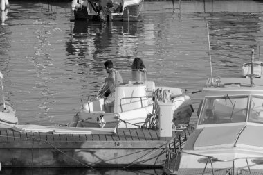 İtalya, Sicilya, Akdeniz, Marina di Ragusa (Ragusa Eyaleti); limanda bir motorlu teknede çift 