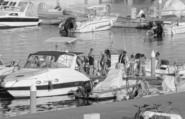 İtalya, Sicilya, Akdeniz, Marina di Ragusa (Ragusa ili); 7 Ağustos 2021, limandaki insanlar, motorlu tekneler ve lüks yatlar - EDITORIAL