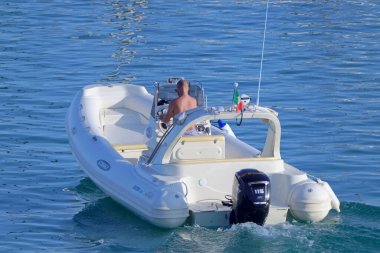 İtalya, Sicilya, Akdeniz, Marina di Ragusa (Ragusa ili); 7 Ağustos 2021, limandaki kauçuk bir teknede adam - EDITORIAL