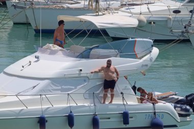 İtalya, Sicilya, Akdeniz, Marina di Ragusa (Ragusa Eyaleti); 9 Ağustos 2021, limanda lüks bir yatta insanlar - EDITORIAL
