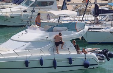 İtalya, Sicilya, Akdeniz, Marina di Ragusa (Ragusa Eyaleti); 9 Ağustos 2021, limanda lüks bir yatta insanlar - EDITORIAL