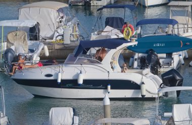 İtalya, Sicilya, Akdeniz, Marina di Ragusa (Ragusa Eyaleti); 9 Ağustos 2021, limanda lüks bir yatta insanlar - EDITORIAL