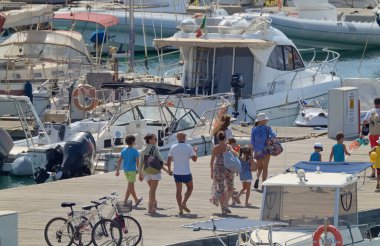 İtalya, Sicilya, Akdeniz, Marina di Ragusa (Ragusa ili); 10 Ağustos 2021, limandaki insanlar, motorlu tekneler ve lüks yatlar - EDITORIAL