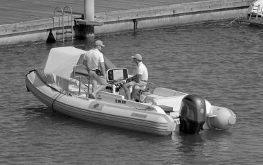 İtalya, Sicilya, Akdeniz, Marina di Ragusa (Ragusa ili); 10 Ağustos 2021, limandaki kauçuk bir teknede erkekler - EDITORIAL