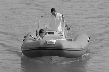 İtalya, Sicilya, Akdeniz, Marina di Ragusa (Ragusa ili); 12 Ağustos 2021, limanda bir kauçuk teknede çift - EDITORIAL