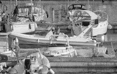 İtalya, Sicilya, Akdeniz, Marina di Ragusa (Ragusa Eyaleti); 13 Ağustos 2021, limandaki kauçuk bir tekne ve lüks yatlarda adam - EDITORIAL