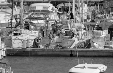 İtalya, Sicilya, Akdeniz, Marina di Ragusa (Ragusa ili); 18 Ağustos 2021, limandaki insanlar ve lüks yatlar - EDITORIAL