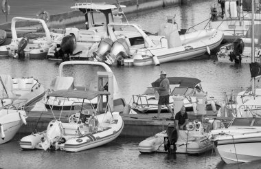 İtalya, Sicilya, Akdeniz, Marina di Ragusa (Ragusa Eyaleti); 19 Ağustos 2021, gün batımında limanda halk, motorlu tekne ve lüks yatlar - EDITORIAL