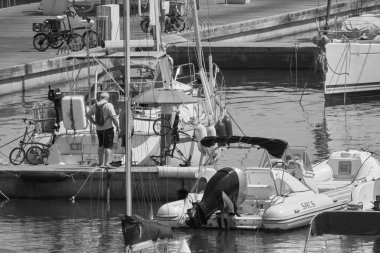 İtalya, Sicilya, Akdeniz, Marina di Ragusa (Ragusa ili); 20 Ağustos 2021, limandaki insanlar ve lüks yatlar - EDITORIAL