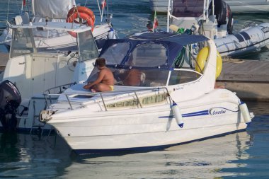 İtalya, Sicilya, Akdeniz, Marina di Ragusa (Ragusa Eyaleti); 21 Ağustos 2021, limanda lüks bir yatta insanlar - EDITORIAL