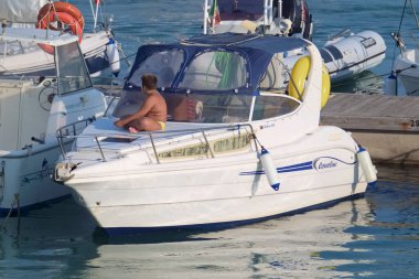 İtalya, Sicilya, Akdeniz, Marina di Ragusa (Ragusa Eyaleti); 21 Ağustos 2021, limanda lüks bir yatta insanlar - EDITORIAL