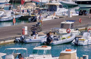 İtalya, Sicilya, Akdeniz, Marina di Ragusa (Ragusa Eyaleti); 24 Mayıs 2021, limandaki insanlar, motorlu tekneler ve lüks yatlar - EDITORIAL