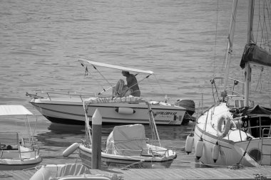 İtalya, Sicilya, Akdeniz, Marina di Ragusa (Ragusa Eyaleti); 1 Eylül 2021, limanda bir motorlu tekne ve lüks yatlarda adam - EDITORIAL