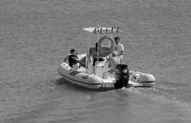 Taly, Sicilya, Akdeniz, Marina di Ragusa (Ragusa Eyaleti); 5 Eylül 2021, limandaki bir kauçuk teknede insanlar - EDITORIAL