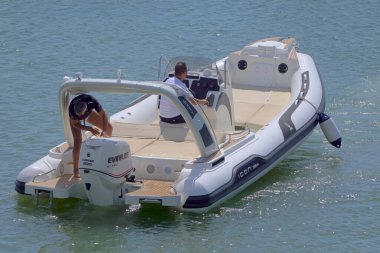 İtalya, Sicilya, Akdeniz, Marina di Ragusa (Ragusa Eyaleti); 12 Eylül 2021, limanda bir kauçuk teknede erkekler - EDITORIAL