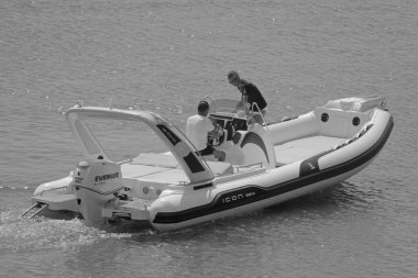 İtalya, Sicilya, Akdeniz, Marina di Ragusa (Ragusa Eyaleti); 12 Eylül 2021, limanda bir kauçuk teknede erkekler - EDITORIAL