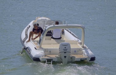 İtalya, Sicilya, Akdeniz, Marina di Ragusa (Ragusa Eyaleti); 12 Eylül 2021, limanda bir kauçuk teknede erkekler - EDITORIAL