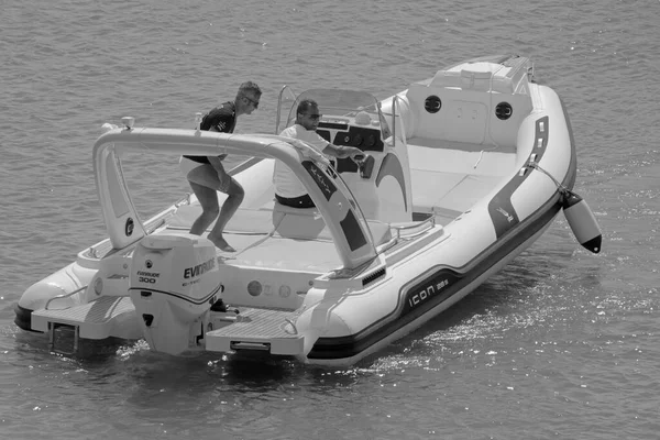 İtalya, Sicilya, Akdeniz, Marina di Ragusa (Ragusa Eyaleti); 12 Eylül 2021, limanda bir kauçuk teknede erkekler - EDITORIAL