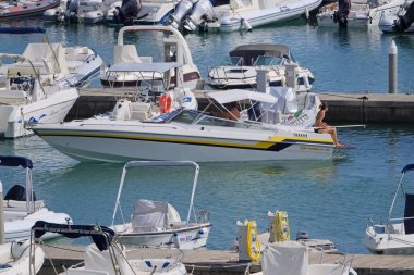 İtalya, Sicilya, Akdeniz, Marina di Ragusa (Ragusa Eyaleti); 15 Eylül 2021, limanda lüks bir yatta çift - EDITORIAL