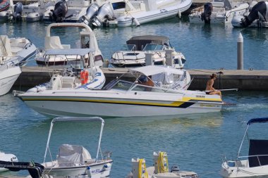 İtalya, Sicilya, Akdeniz, Marina di Ragusa (Ragusa Eyaleti); 15 Eylül 2021, limanda lüks bir yatta çift - EDITORIAL