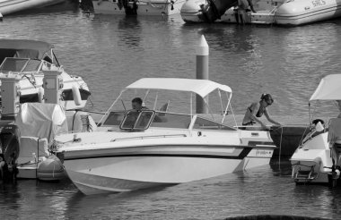 İtalya, Sicilya, Akdeniz, Marina di Ragusa (Ragusa Eyaleti); 15 Eylül 2021, limanda lüks bir yatta çift - EDITORIAL