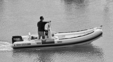 İtalya, Sicilya, Akdeniz, Marina di Ragusa (Ragusa Eyaleti); 16 Eylül 2021, limandaki bir lastik teknede adam - EDITORIAL