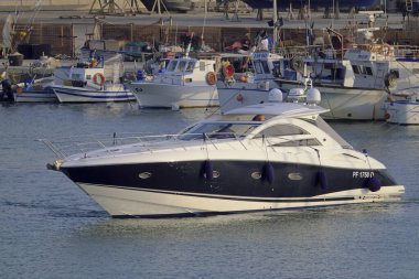 İtalya, Sicilya, Akdeniz, Marina di Ragusa (Ragusa ili); 16 Eylül 2021, lüks bir yat ve limandaki yerel balıkçı tekneleri - EDITORIAL