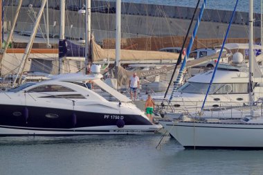 İtalya, Sicilya, Akdeniz, Marina di Ragusa (Ragusa Eyaleti); 16 Eylül 2021, limanda lüks bir yatta erkekler - EDITORIAL