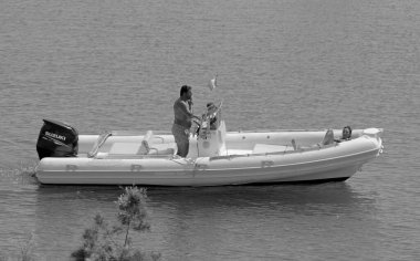 İtalya, Sicilya, Akdeniz, Marina di Ragusa (Ragusa Eyaleti); 18 Eylül 2021, limandaki kauçuk bir teknede insanlar - EDITORIAL